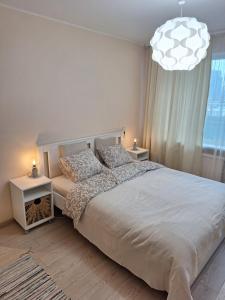 Un dormitorio con una cama grande y una lámpara de araña. en Rinktinės apartments, en Vilna