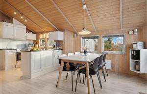 a kitchen and dining room with a table and chairs at Holiday Home Pøt Strandby Denmark Ix in Sønderby