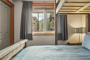 a bedroom with a large bed and a window at Pines & Peaks 2 Bedroom Mountain Retreat in Canmore +24 photos