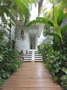 un chemin en bois menant à une maison arborée dans l'établissement Casa Barra do Una Sol, Mar e Cahoeiras, à São Sebastião 23 autres photos