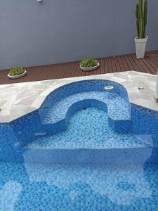 une piscine en mosaïque bleue dans un patio avec des plantes dans l'établissement Casa Barra do Una Sol, Mar e Cahoeiras, à São Sebastião