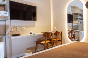 a room with a table and chairs and a television at Littoral Express in João Pessoa