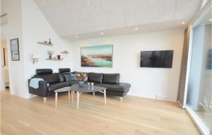 a living room with a black couch and a table at Two-Bedroom Apartment In Thisted in Thisted