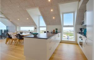 a kitchen and dining room with a table and some windows at Two-Bedroom Apartment In Thisted in Thisted