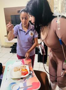 two women looking at a plate of food on a table at Dr House Casa de Recuperación Post Quirúrgica in Guayaquil