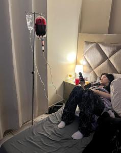 a woman laying on a bed in a room at Dr House Casa de Recuperación Post Quirúrgica in Guayaquil