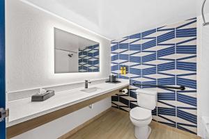 a bathroom with a toilet and a sink and a mirror at Best Western Plus Lower South End in Charlotte +17 photos