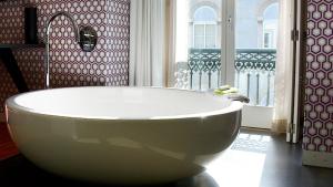 a white bath tub in a bathroom with a window at Inspira Liberdade Boutique Hotel in Lisbon