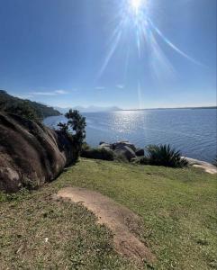 a view of a body of water with the sun at Refugio Bela Ilha Luxo Casal Acesso por Barco in Florianópolis