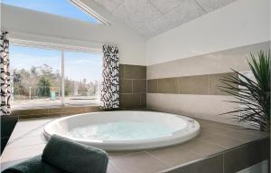 a large bath tub in a room with a window at Nice Home In Ålbæk With Kitchen in Ålbæk +17 photos