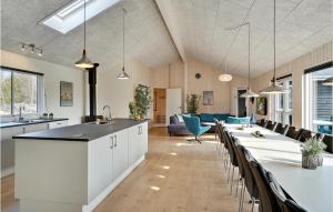 a kitchen and living room with a long table and chairs at Nice Home In Ålbæk With Kitchen in Ålbæk