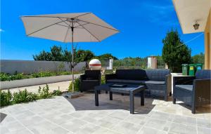 un patio con un tavolo e un ombrellone di 3 Bedroom Beautiful Home In Muntic a Muntić