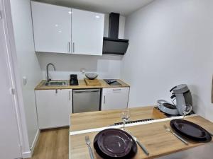 eine Küche mit weißen Schränken und einer Holzarbeitsplatte in der Unterkunft Cosy Des Rêves in Villiers-sur-Marne + 4 Fotos