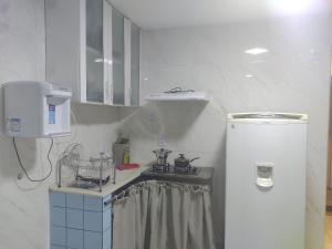 a small kitchen with a refrigerator and a sink at Apto 352 centro nucleo bandeirant in Brasilia