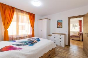 a bedroom with a bed and a dresser and a window at Villa Nikol Apartment #1 in Raduil
