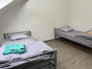 two twin beds in a room with at Appartement J, RESIDENCE DU RENOUVEAU, Stade de France, idéal pour 4 pers in Saint-Denis