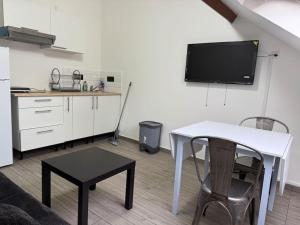 a living room with a white table and a tv at Appartement J, RESIDENCE DU RENOUVEAU, Stade de France, idéal pour 4 pers in Saint-Denis