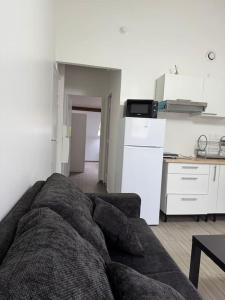 a living room with a couch and a kitchen at Appartement J, RESIDENCE DU RENOUVEAU, Stade de France, idéal pour 4 pers in Saint-Denis +1 photo