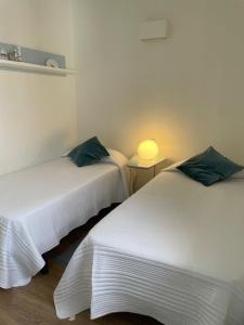 una stanza con due letti e un tavolo con una lampada di San Agustín BeachSun Relax a San Bartolomé