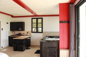 a kitchen with red walls and a red column at Ferme de restantier, love room in La Tour-dʼAigues