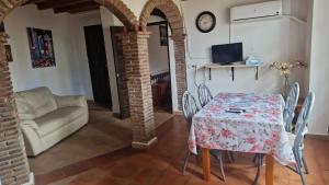 a dining room with a table and chairs and a couch at Apartamento mesón in Iznate