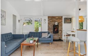 a living room with two blue couches and a table at 2 Bedroom Amazing Home In Nexø in Neksø