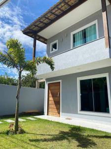 ein Haus mit einer Holztür und einer Palme in der Unterkunft Casa em Búzios in Búzios