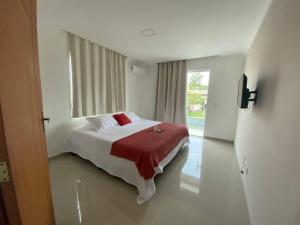 ein Schlafzimmer mit einem Bett mit einer roten Decke und einem Fenster in der Unterkunft Casa em Búzios in Búzios + 38 Fotos