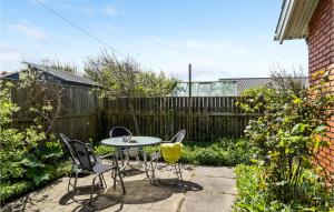 Un patio con mesa y sillas y una valla. en Awesome Home In Thyborøn With Wifi, en Thyborøn