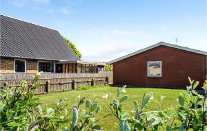 una casa de ladrillo rojo con una valla de madera en Awesome Home In Thyborøn With Wifi, en Thyborøn 10 fotos más