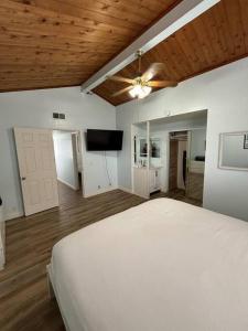 a bedroom with a white bed and a flat screen tv at Newport Beach Rendezvous in Newport Beach