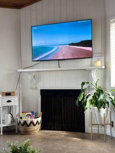 a flat screen tv above a fireplace in a living room at Newport Beach Rendezvous in Newport Beach