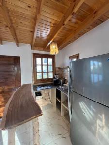 a kitchen with a stainless steel refrigerator and wooden ceilings at A sunny Bohemian chalet in Dahab in Dahab