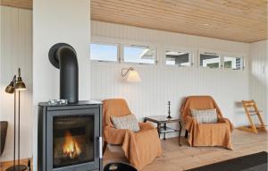ein Wohnzimmer mit zwei Stühlen und einem Kamin in der Unterkunft 3 Bedroom Beautiful Home In Ebeltoft in Ebeltoft