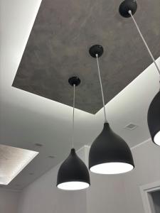 three black lights hanging from a ceiling at B&B Stella in Somma Lombardo +20 photos