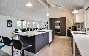 a large kitchen with a large island in the middle at Nice Home In Spøttrup With Sauna in Spottrup