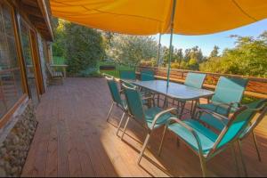 a patio with a table and chairs and an umbrella at Casa en Puerto Varas in Puerto Varas