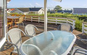 a table and chairs sitting on a deck with a table and chairs at Holiday Home Hvedemarken Sjølund Iii in Hejls