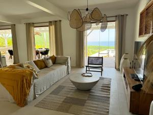 a living room with a couch and a table at Villa Ti Piou in Deshaies +35 photos