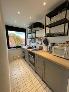 a kitchen with a sink and a microwave and a window at Auszeit am Kurpark I 24h Check-In I WLAN in Bad Salzuflen