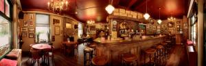 a bar in a pub with a large wooden counter at Hotel Restaurant Café Parkzicht in Roermond