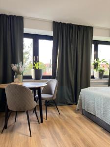 a bedroom with a table and chairs and a bed at Auszeit am Kurpark I 24h Check-In I WLAN in Bad Salzuflen