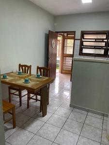 a kitchen with a table and chairs in a room at LARA'S HOUSE in São Sebastião