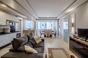 a living room with a couch and a table at Apto vista mar a 200m do mar c/ 2 qts BC EBC0603 in Balneário Camboriú