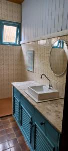 a bathroom counter with a sink and a mirror at Casa aconchegante perto da praia in Guarujá +10 photos