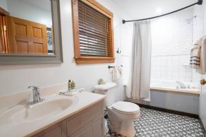 a bathroom with a sink and a toilet and a tub at Cozy Cabin Smoky Mountains - Hot tub, pool, & golf in Townsend +24 photos