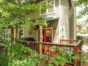 a house with a wooden deck with a red door at Cozy Cabin Smoky Mountains - Hot tub, pool, & golf in Townsend