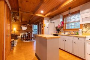 a kitchen with white cabinets and a wooden ceiling at Cozy Cabin Smoky Mountains - Hot tub, pool, & golf in Townsend