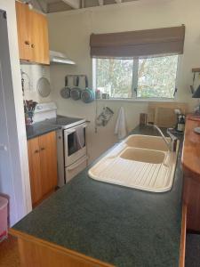 ワイカナエにあるBeside the lagoon - Waikanae Beachのシンクとカウンタートップのあるキッチン