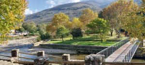 a bridge over a river with a mountain in the background at El Cantillo del Jerte in Cabezuela del Valle